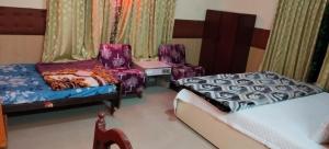 a bedroom with two beds and a table and chairs at Friends cottage in Coonoor
