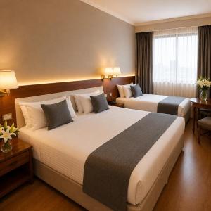 a hotel room with two beds and a window at Hotel Centuria Obelisco in Buenos Aires +51 photos