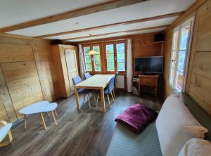 a living room with a table and a couch at Chalet Sonnenheim mit atemberaubender Aussicht in Adelboden
