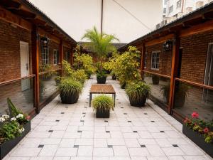 an outdoor patio with potted plants and a table at Hotel Centuria Obelisco in Buenos Aires