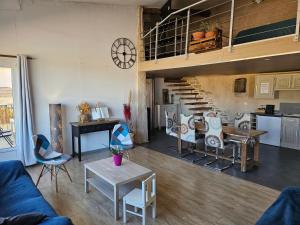 a living room with a blue couch and a staircase at Loft in Aujeurres