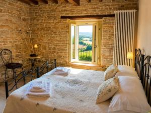 a bedroom with a large bed with a window at Dimora nel Castello di Loretello in Loretello