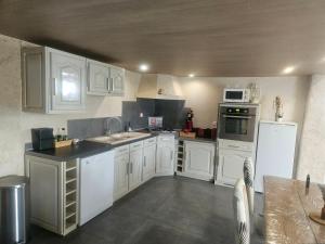 a kitchen with white cabinets and white appliances at Loft in Aujeurres