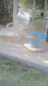 a white bench and a table and a toy at Chez Georges in Sainte-Anne