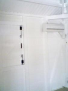 a white door with a black hinges on it at Chez Georges in Sainte-Anne