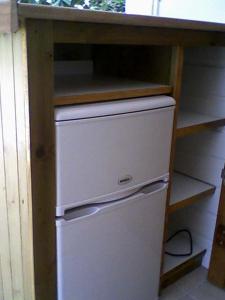 a white refrigerator under a counter in a kitchen at Chez Georges in Sainte-Anne