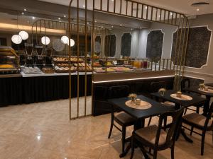 a restaurant with two tables and a buffet at Hotel Centuria Obelisco in Buenos Aires