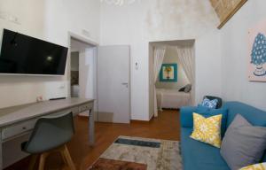 a living room with a blue couch and a desk at Capo Rama Suites & Rooms in Terrasini