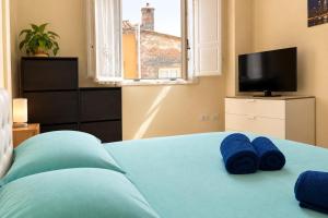 a bedroom with a bed with blue towels on it at Dimora Leonardo. Centro Storico. in Lucca