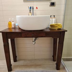 a sink on a wooden table in a bathroom at Casa Magenta Appartamento con giardino e bbq ad Asti in Asti