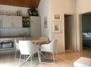 a kitchen with a wooden table and white chairs at Landleben - Ferienhaus 2 in Fritzlar +27 photos