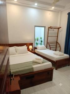 two beds in a room with a window at MSM Diamond Villa in Wattala