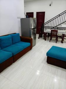 a living room with blue couches and a table at MSM Diamond Villa in Wattala