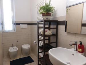 a bathroom with a sink and a toilet and a plant at Casa Magenta Appartamento con giardino e bbq ad Asti in Asti