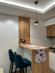 a kitchen with a counter and two chairs at Apartman Porta 108 in Kruševac +2 photos