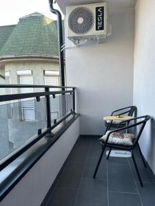 a balcony with a chair and a fan on a building at Apartman Porta 108 in Kruševac