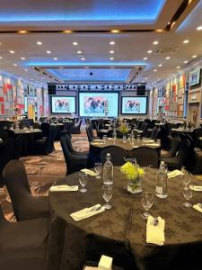 a banquet hall with tables and chairs and projection screens at KL International Hotel in Kuala Lumpur
