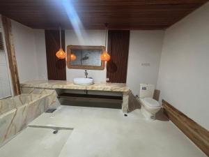 a bathroom with a sink and a toilet at Batur Panorama in Kintamani +88 photos