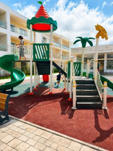 a playground in front of a building with a slide at Pool View Apartment Gated Residence in Sidi Rahal