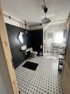 a bathroom with a toilet and a black and white tile floor at Winnica Bursztynowa in Możdżanowo +48 photos