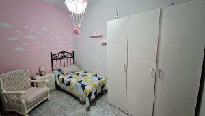 a childs bedroom with a bed and a chair at Villa Izael AT-BA-00317 in Talavera la Real