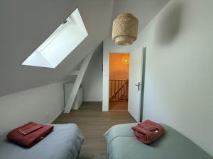 a white room with two beds and a window at Chtî arq in Arques-la-Bataille