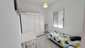 a small bedroom with a bed and a table at Villa Izael AT-BA-00317 in Talavera la Real