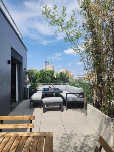 a patio with a couch and a table and benches at Penthouse 166 m2- Terrasse & Parking - Paris Sud - Orly - Parc Expo in Bagneux +46 photos