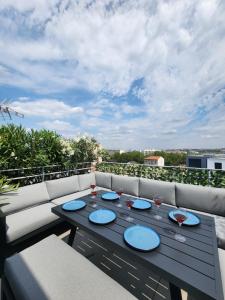 a wooden table with wine glasses on a balcony at Penthouse 166 m2- Terrasse & Parking - Paris Sud - Orly - Parc Expo in Bagneux