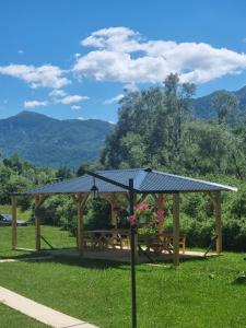 a gazebo with a picnic table in the grass at durmitor's golden peace in Šavnik