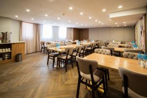 a conference room with tables and chairs in a room at Ustyurt boutique hotel in Aktau