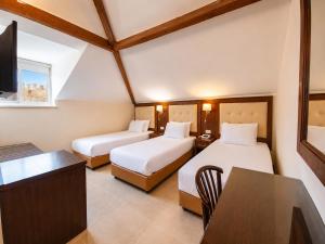 a hotel room with two beds and a table at The Annexe - by Gloria Hotel in Jerusalem