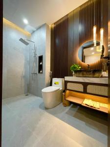 a bathroom with a toilet and a sink and a mirror at Vin Luxury Hotel in Quang Tri