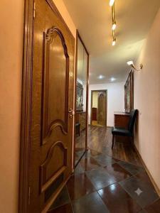 a hallway with a wooden door and a chair at Центр Пассаж ЦУМ in Dnipro