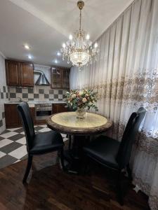 a kitchen with a table with chairs and a vase of flowers at Центр Пассаж ЦУМ in Dnipro