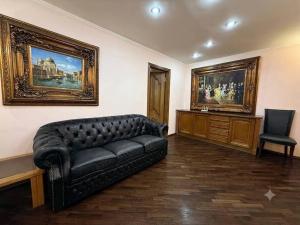 a living room with a black leather couch and a chair at Центр Пассаж ЦУМ in Dnipro