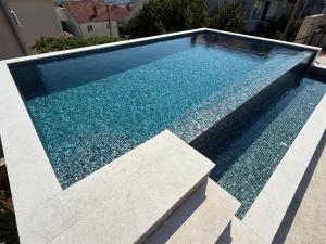 a swimming pool with blue water in a house at B&B Guest House Vasiljevic in Herceg-Novi