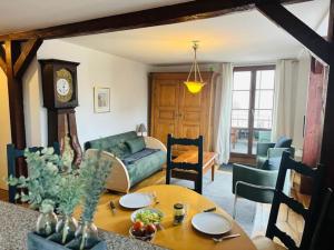 a living room with a green couch and a table at Au Bonheur des Anges Appartement 2 chambres avec terrasse in Colmar