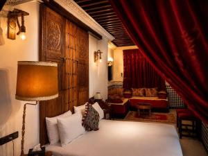 a living room with a bed and a red curtain at Dar Laabi - Riad Aya in Fez