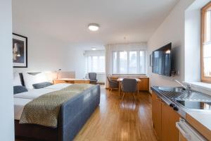 a bedroom with a bed and a kitchen with a table at Studiowohnungen am Rieger-Hof in Hartmannsdorf