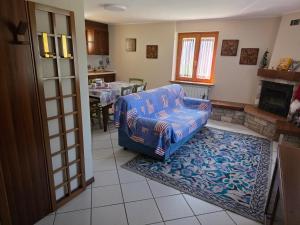 a living room with a blue chair and a rug at Casa con giardino e garage vicino alle piste in San Pietro