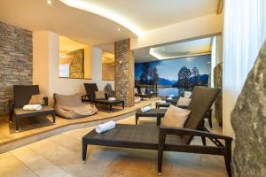 a lobby with chairs and tables and a wall mural at Hotel Alpenwelt Superior in Flachau