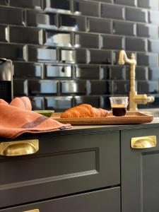 a counter with a plate of bread and a glass of sauce at Le Cathedral View Colmar - Centre Historique - Parking privé gratuit in Colmar +26 photos