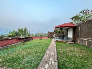 a garden with a house and a brick path at Villa Kay Terrace in Campaka