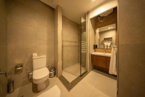 a bathroom with a toilet and a shower and a sink at Regency Nile Hotel Assuit in Al Ḩamrāʼ