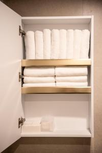a bathroom closet with white towels on shelves at 호텔느릿 in Seoul +60 photos