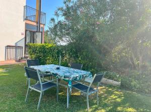 a table with four chairs in a yard at Maison Margherita in Calmasino