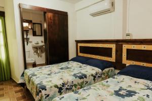 a bedroom with two beds and a sink at Hotel Posada San Agustin in Xilitla