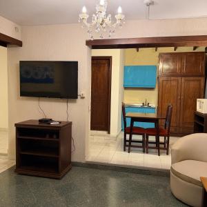a living room with a dining room table and a television at Hotel Hassler in Asunción