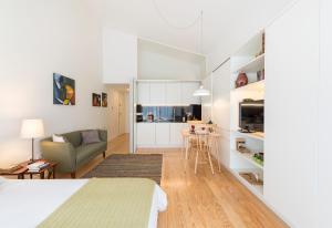 a white living room with a couch and a table at Bright Downtown Apartment in Porto